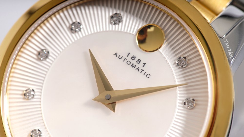 Đồng hồ Movado 0607489 - Bộ kim dauphine sắc sảo và chấm tròn đặc trưng mạ vàng gold của Movado 0607489 